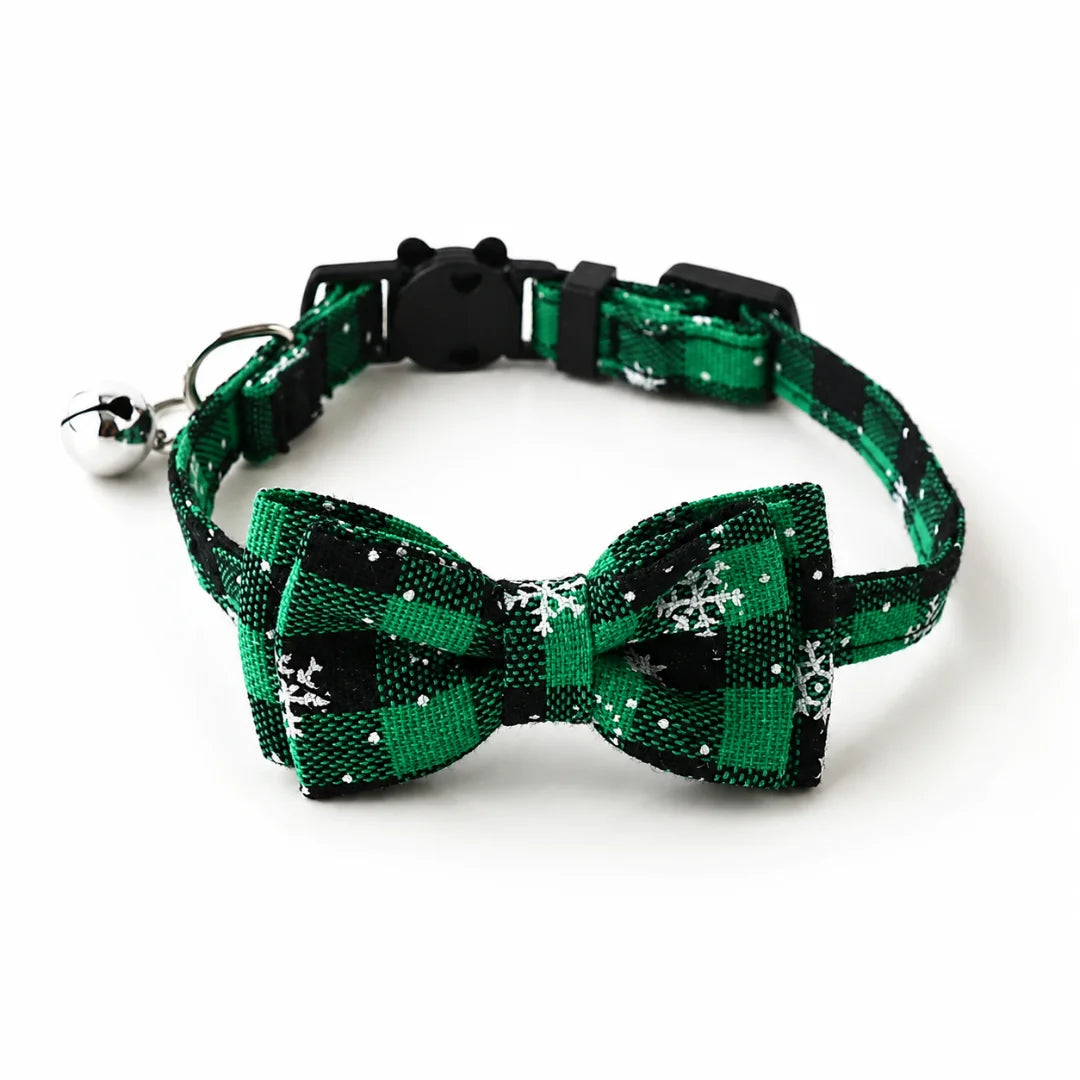 Green and black plaid Christmas cat collar featuring snowflakes and a silver bell.