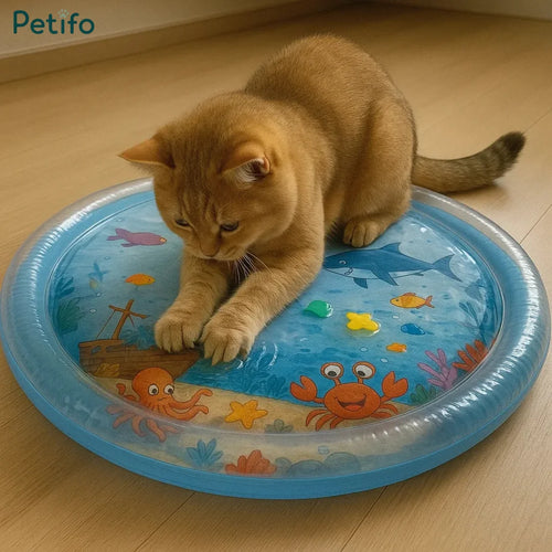 Golden cat playing on a blue inflatable sensory water mat with ocean graphics.