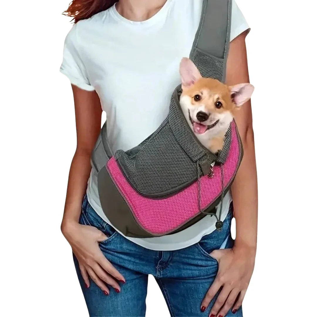 Happy Corgi puppy traveling comfortably in a pink and grey breathable mesh pet sling bag.