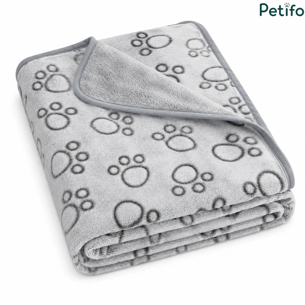 Folded grey fleece puppy blanket featuring a cute paw print pattern and smooth piped edging.