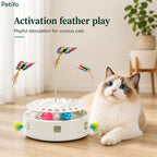 A curious cat resting beside a white automatic cat toy featuring active feather play and colorful butterfly attachments.